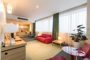 a living room with a red couch and a table at Mirage Hotel in Kazan +8 photos