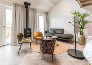ein Wohnzimmer mit einem Sofa und Stühlen in der Unterkunft Villa Noordzee in Renesse