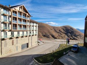 un edificio con parcheggio accanto a una montagna di New Gudauri Studio a Gudauri