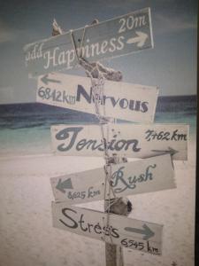 un letrero en la playa con varias señales en Location Chambre Sare Larhun Zola 2022 en Sare