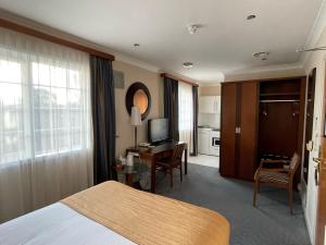 a hotel room with a bed and a television at Best Western Homestead Court Hotel in Welwyn Garden City