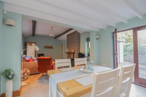 una sala da pranzo e un soggiorno con tavolo e sedie di Camerton Hall Cottage a Workington
