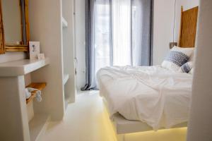een witte slaapkamer met een bed en een wastafel bij 8 Keys Residence in Naousa