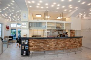 a kitchen with white cabinets and a brick counter at Relax Hotel & SPA Stuttgart in Stuttgart