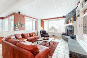 sala de estar con sofá de cuero y chimenea en Yankee Sno-Home, en Big White
