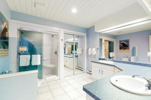 Un baño azul con lavabo y ducha. en Yankee Sno-Home, en Big White 21 fotos más