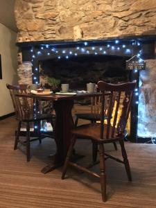 a table with chairs and a fireplace with lights at The Lake View Hotel in Llanberis