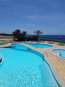 una piscina con l'oceano sullo sfondo di Westhaven Bay a Costa Del Silencio