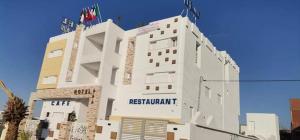 ein großes weißes Gebäude mit einem Schild darauf in der Unterkunft Hotel al rayan in Tataouine