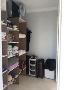 a room with a closet with shelves and luggage at Casa da Lis com Piscina in Palhoça