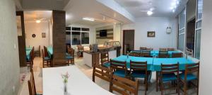 a dining room with a blue table and chairs at Pousada Bella Nina in Balneário Camboriú +35 photos