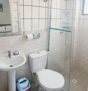 a bathroom with a toilet and a sink and a shower at Pousada Bella Nina in Balneário Camboriú