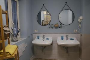 ein Badezimmer mit zwei Waschbecken und zwei Spiegeln in der Unterkunft B&B BINARIO 39 in Neapel