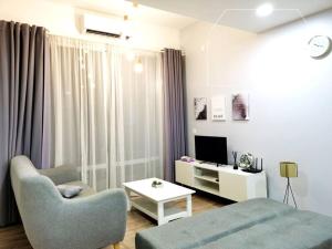 a living room with a couch and a chair and a television at Designer Muji Penthouse Johor Bahru/Paradigm in Johor Bahru