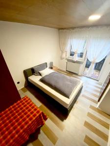 ein Schlafzimmer mit einem großen Bett und zwei Fenstern in der Unterkunft Bellas Mühlbachtal in Friedenfels