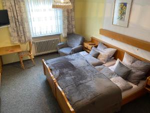 a bedroom with a bed and a chair and a desk at Bellas Mühlbachtal in Friedenfels