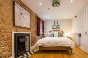 a bedroom with a bed and a brick wall at The Dog & Gun Inn in Netheravon