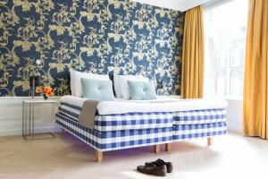 een slaapkamer met een bed met blauw en goud behang bij Amsterdam Canal Hotel in Amsterdam