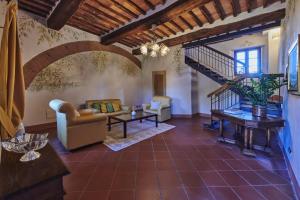 a living room with a spiral staircase in a house at Villa Curina Resort in Castelnuovo Berardenga