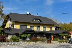 a yellow and black house with a black roof at Hotel Gostilna Vovko in Novo Mesto