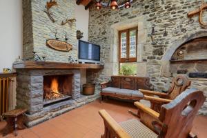 a living room with a stone wall with a fireplace at Can Soler de Merlant in Porqueres