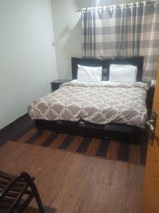 Bett in einem Schlafzimmer mit Holzboden in der Unterkunft Four Season Guest House in Islamabad