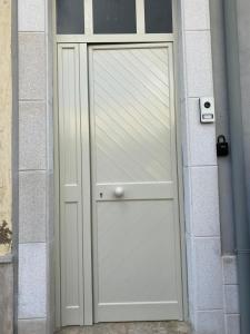 a white door in the side of a building at La casa di Francesca in Campobello di Licata
