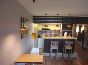 a kitchen with a blue counter and two stools at Résidence le Faucon - Col du Donon in Grandfontaine