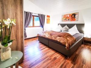 1 dormitorio con 1 cama y suelo de madera en Alpenchalet Dona en Partenen