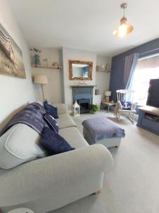 a living room with a white couch and a table at Sanderlings - Suffolk Coastal Escapes in Pakefield