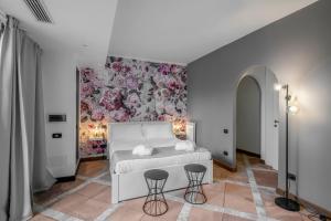 sypialnia z białym łóżkiem i kwiatową ścianą w obiekcie La Locanda Del Pontefice - Luxury Country House w mieście Castel Gandolfo +37 zdjęć