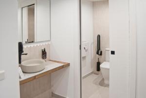 a bathroom with a sink and a toilet at Aparthotel El Cargol in L'Escala