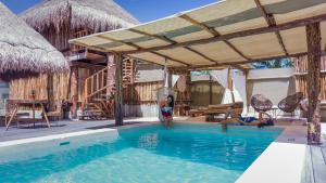 a woman standing in a swimming pool at a resort at Hotel Jungla y Estrellas in Coba