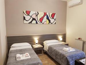 a room with two beds and a painting on the wall at B&B Monté in Montesilvano