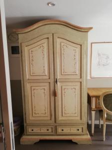 a large wooden cabinet sitting next to a table at B & B San Domenico in Chioggia
