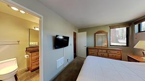 a bedroom with a bed and a toilet and a television at Lakeview 826 Condo #553 Condo in Mammoth Lakes +34 photos