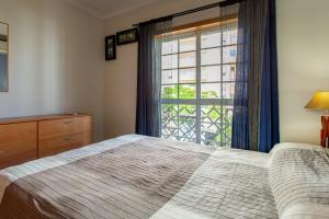 um quarto com uma cama e uma grande janela em Casa das Lontras em Faro