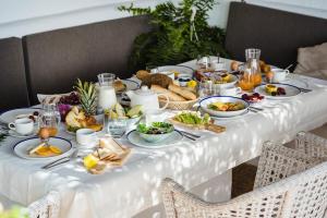 una mesa llena de comida para el desayuno en un mantel blanco en Casas Heddy, Well-being Resort, en Puerto del Carmen