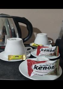 a table topped with two cups and plates with snacks at DOMUS FIESCHI Rooms self check in in Genova