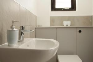 uma casa de banho branca com um lavatório e um WC em Lodges at Flimwell Park em Ticehurst