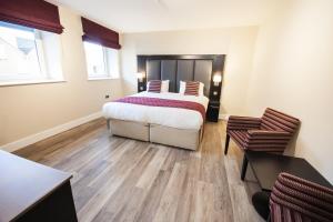 a bedroom with a bed and a table and chairs at Crown Lodge Hotel in Wisbech