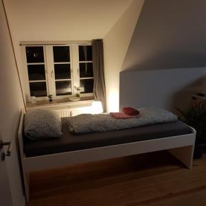 een bed in een kamer met een raam bij Flensburg Zentrum 69 03 in Flensburg