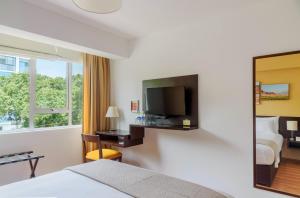 a hotel room with a television and a bed at Girasoles Hotel in Lima