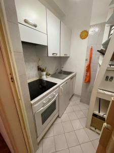 una pequeña cocina con armarios blancos y fregadero en Casa Rosanna, en Rapallo