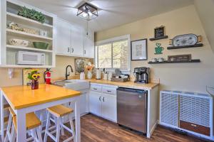 a kitchen with white cabinets and a wooden counter top at Lake Arrowhead Studio with Private Hot Tub! in Lake Arrowhead