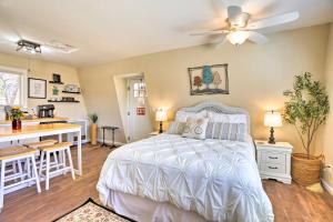 a bedroom with a white bed and a kitchen at Lake Arrowhead Studio with Private Hot Tub! in Lake Arrowhead
