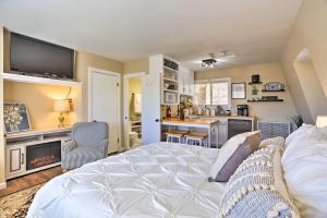 a bedroom with a white bed and a kitchen at Lake Arrowhead Studio with Private Hot Tub! in Lake Arrowhead