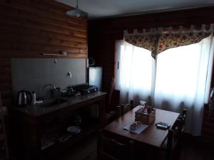 una cucina con tavolo, lavandino e finestra di Cabañas Los Teros a San Pedro