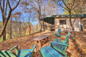 a group of chairs and a picnic table in the woods at Sweet Birch Bryson City Cottage with Views in Bryson City