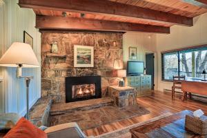 a living room with a large stone fireplace at Sweet Birch Bryson City Cottage with Views in Bryson City